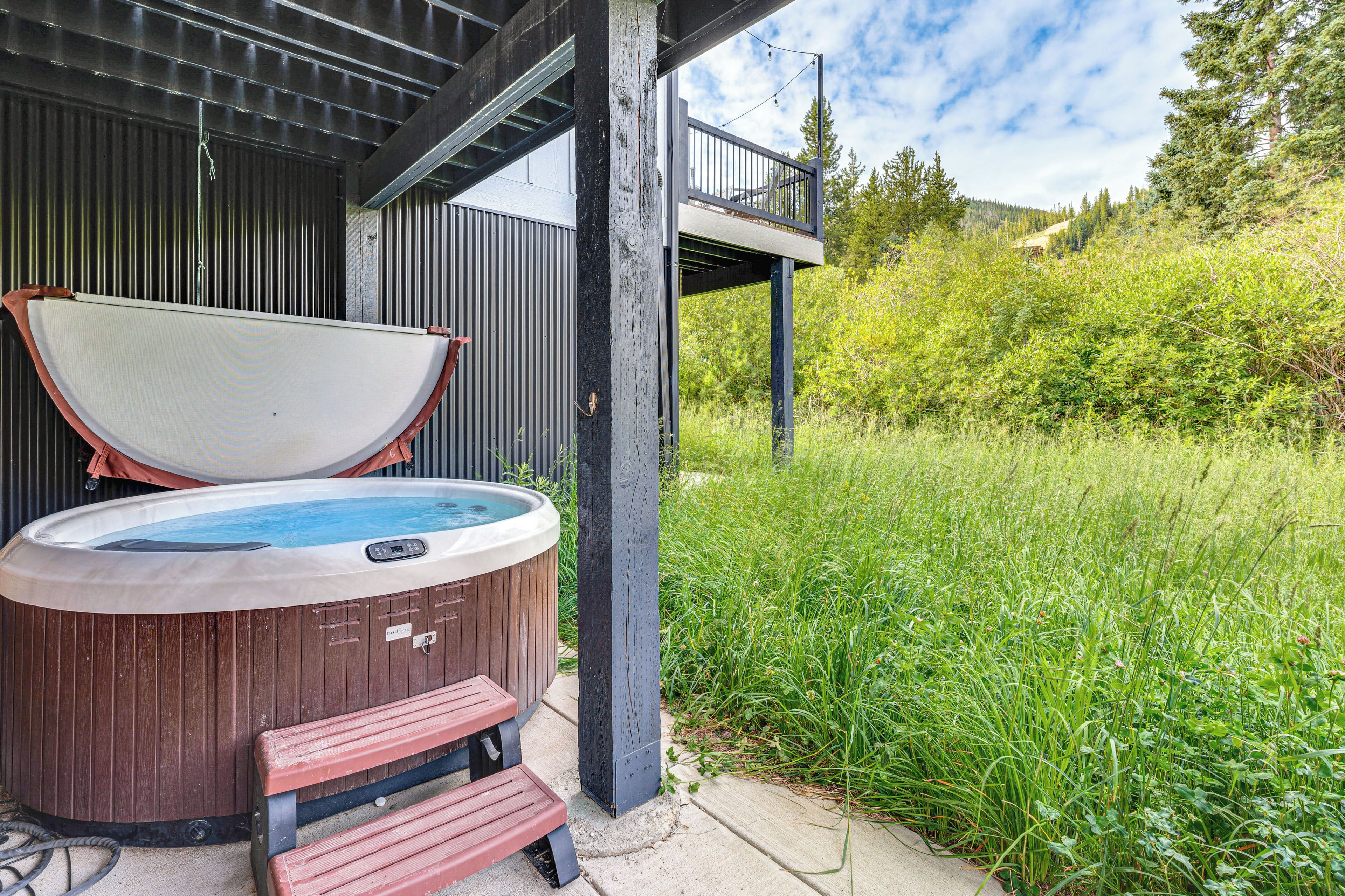 Een hottub met een houten bank en een houten terras.