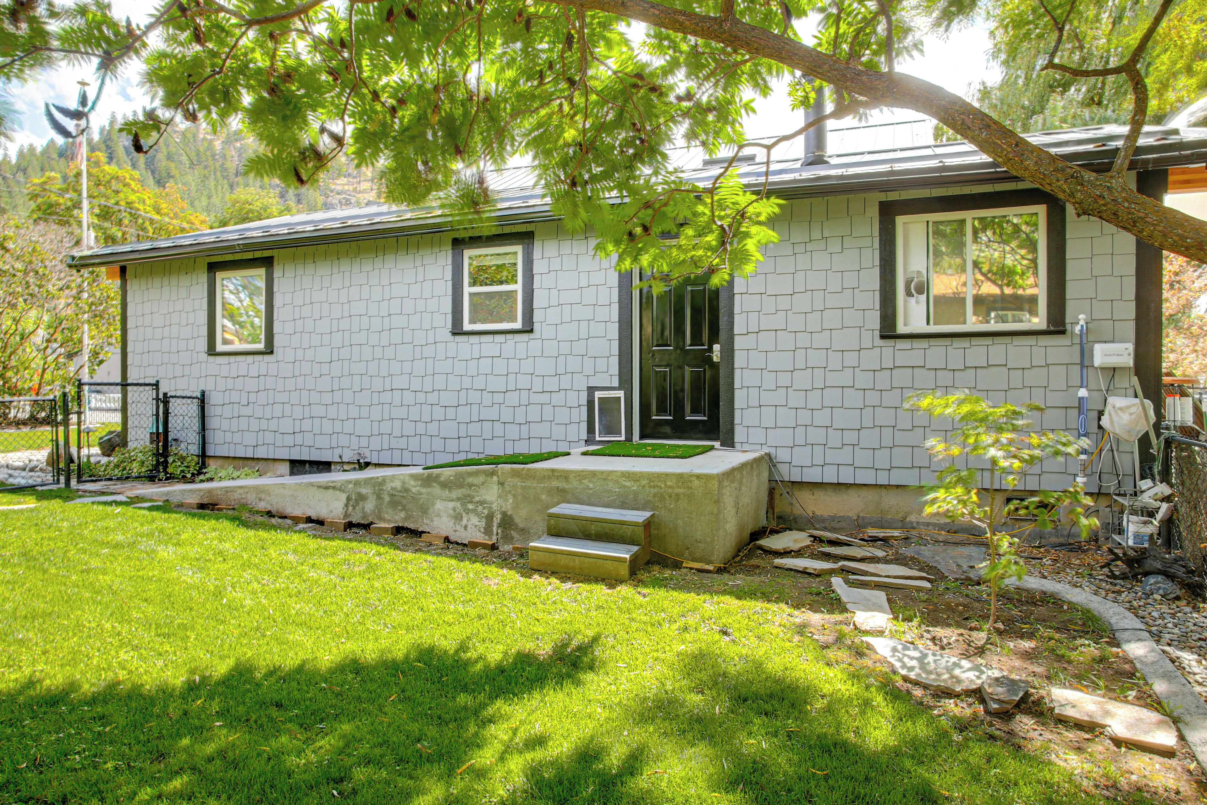 A single-story house with a tiled exterior, a front door, and a small front yard with steps leading up to the door.