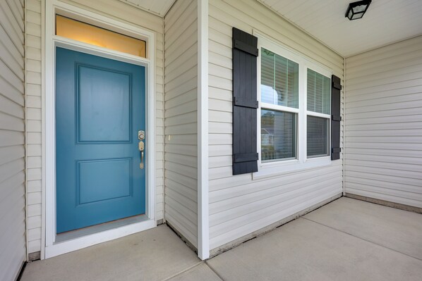 A house with a blue door, white siding, and a window with shutters. - 3 Mi to Golf & Waterway: Ocean Isle Beach Retreat! (Ocean Isle Beach)
