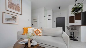 A modern living room with a sofa, coffee table, and framed artwork on the wall.