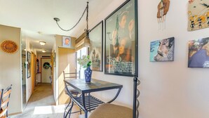 A dining area with a table, chairs, and a vase of flowers. There are framed pictures on the wall. - Walk to Angel Fire Resort: Getaway w/ Balcony (Angel Fire)