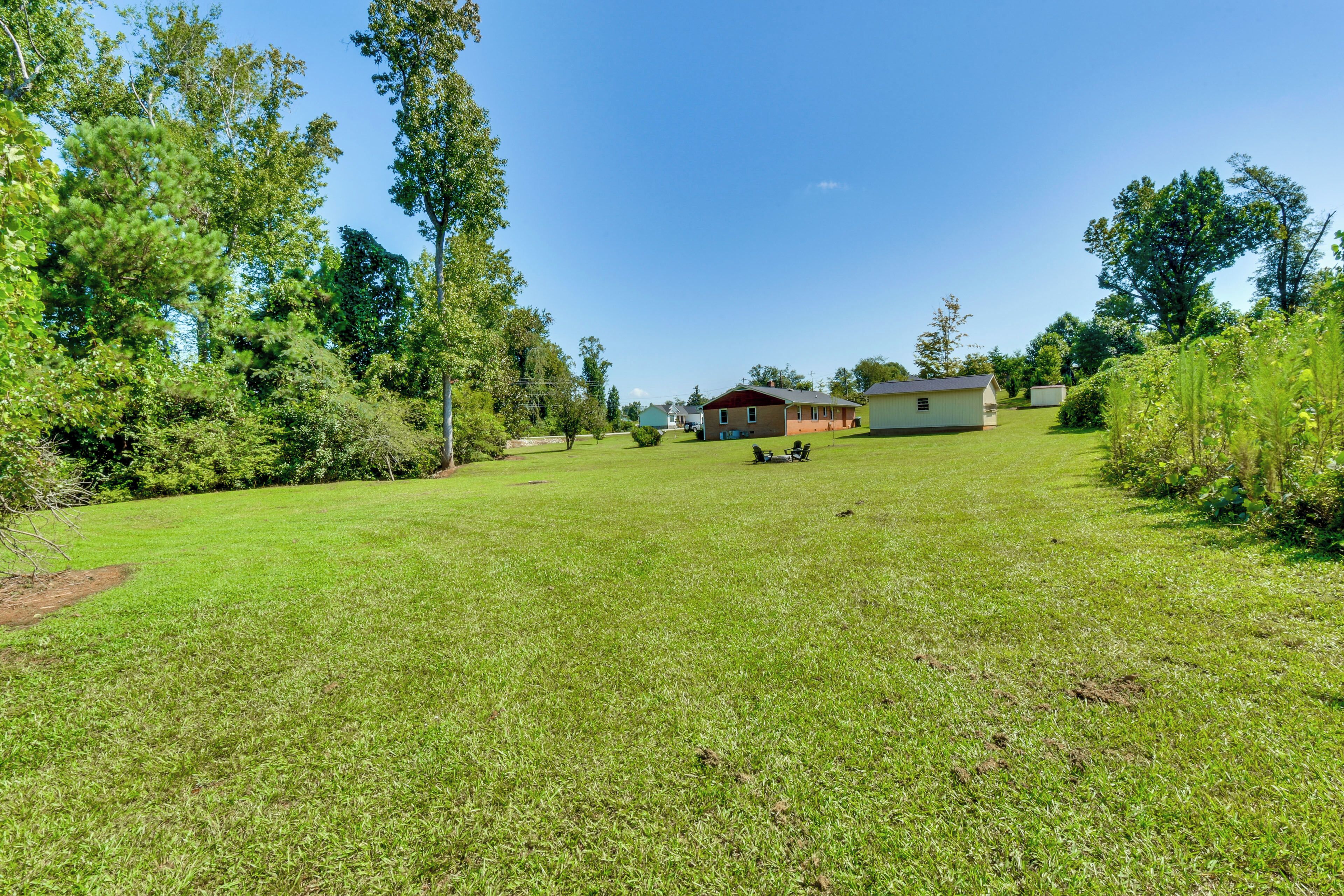 A grassy yard with a house and a shed.