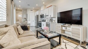 A modern living room with a beige sofa, a glass coffee table, and a flat-screen TV. - Fenced-in Yard: Apt 7 Mi to Westfield Galleria (Roseville)