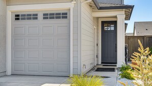 A two-car garage with a dark front door and a small entryway with a step and a doormat. - Fenced-in Yard: Apt 7 Mi to Westfield Galleria (Roseville)