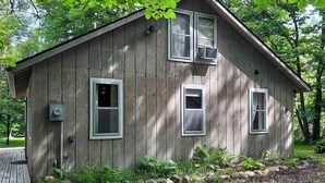 A wooden cabin with two windows, a door, and a small porch. - Lakeside Getaway w/ Dock: West Battle Lake Cabin (Clitherall)