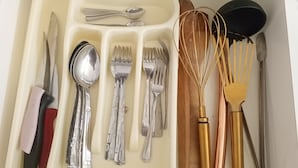 A drawer containing various kitchen utensils including knives, spoons, forks, and whisks. - anka suit (Aydın)