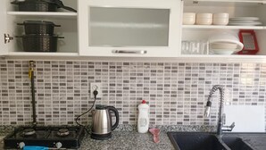 A kitchen with a microwave, kettle, and sink. - anka suit (Aydın)