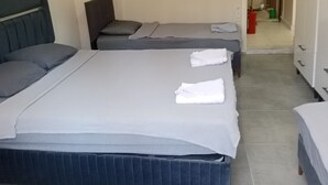 A hotel room with two beds, a wardrobe, and a bathroom visible in the background. - anka suit (Aydın)