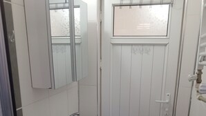 Un baño con lavamanos blanco, un espejo y un inodoro.