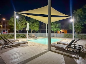 A nighttime pool area with lounge chairs and a canopy. - FIRST CLASS | VILLA | Spacious for Family Getaways (Damac Hills)