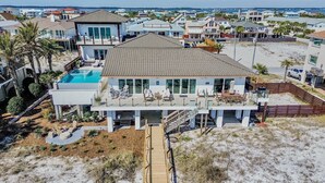 Una casa de dos pisos con piscina, ventanas amplias y un patio cubierto.