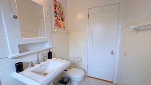 A bathroom with a white sink, a toilet, and a door. - Charming 1BR Apt in Evanston (Evanston)
