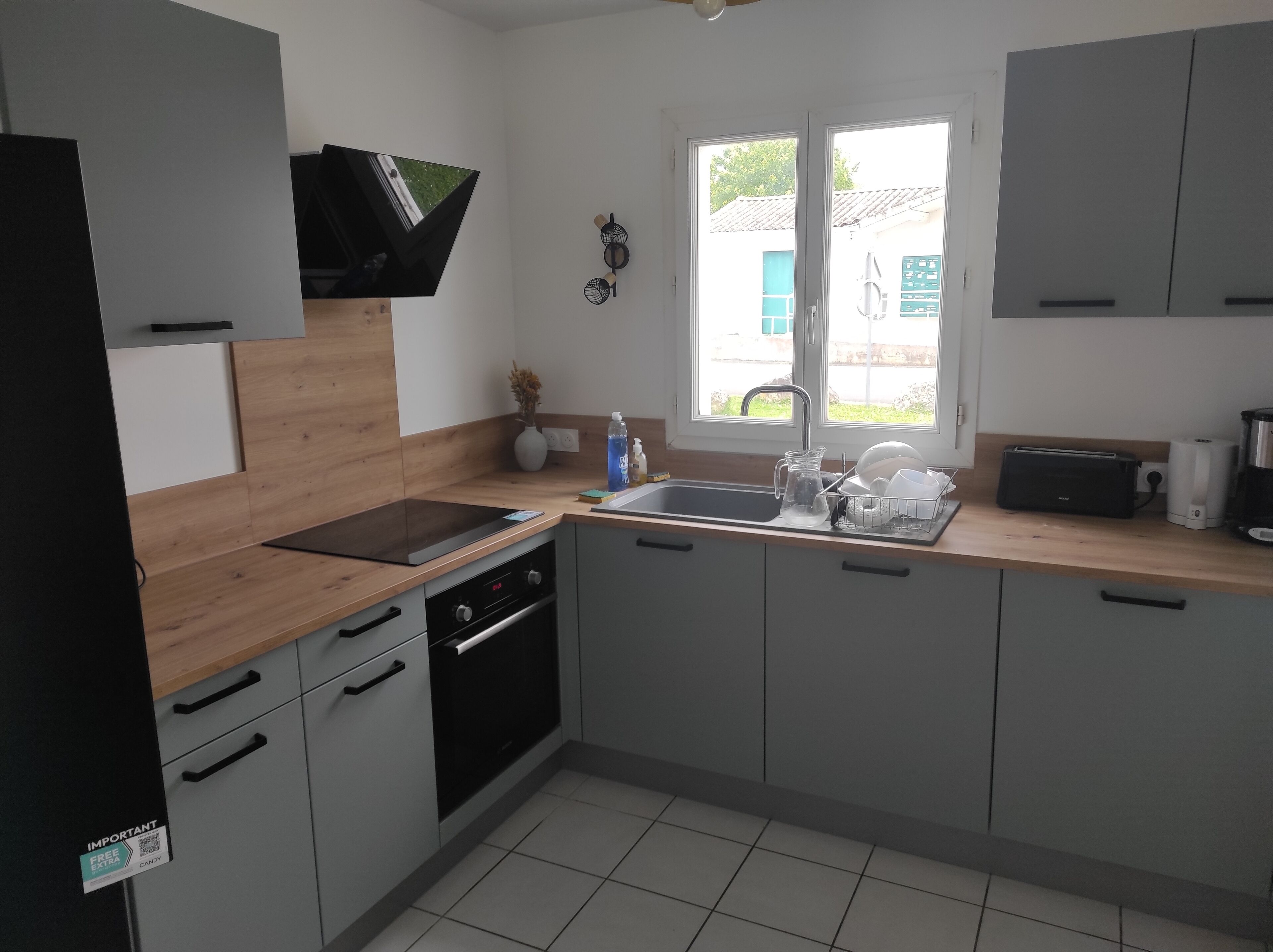 Een moderne keuken met een houten aanrecht, een ingebouwde oven, een spoelbak en een raam met uitzicht.
