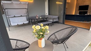 Un patio al aire libre con mesa de comedor, sillas, sofá y zona de descanso.