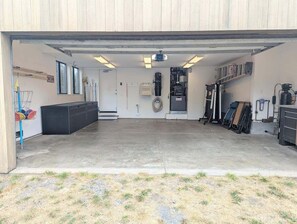 Eine Garage mit Betonboden, einer Werkbank, einem Reifen und einem Radkreuz.