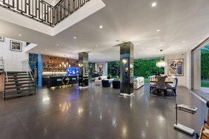 A spacious lobby with a reception desk, seating area, and a staircase.
