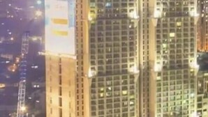 A high-rise building with multiple floors, large windows, and a prominent illuminated sign on the side. - Simple but Cozy, Feel at Home (Mandaluyong)