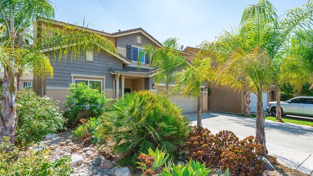 A residential house with a landscaped garden, a driveway, and a parked car. - Bright Airy 5B Home Workspace Outdoor Lounge (Moreno Valley)