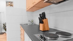 Eine moderne Küche mit einem Gasherd, Holzschränken und einem Messerblock.