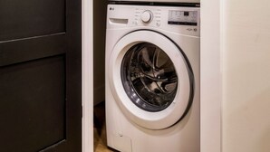 A laundry room with two stacked front-loading washing machines. - Cozy Luxe Home,Breathtaking Mtn. Views of fall foliage, Outdoor sauna,large deck (Sevierville)