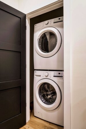 A laundry room with two stacked front-loading washing machines. - Cozy Luxe Home,Breathtaking Mtn. Views of fall foliage, Outdoor sauna,large deck (Sevierville)