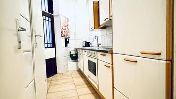 Horno, placa de cocina, utensilios de cocina y mesa de comedor