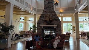 A spacious lobby with a high ceiling, stone fireplace, and multiple seating areas. - Best Amenities Resort- Bonita Spring, FL- 2BD/2BA (Bonita Springs)