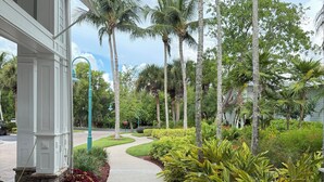 A covered walkway with a curved path, surrounded by lush greenery and palm trees. - Best Amenities Resort- Bonita Spring, FL- 2BD/2BA (Bonita Springs)