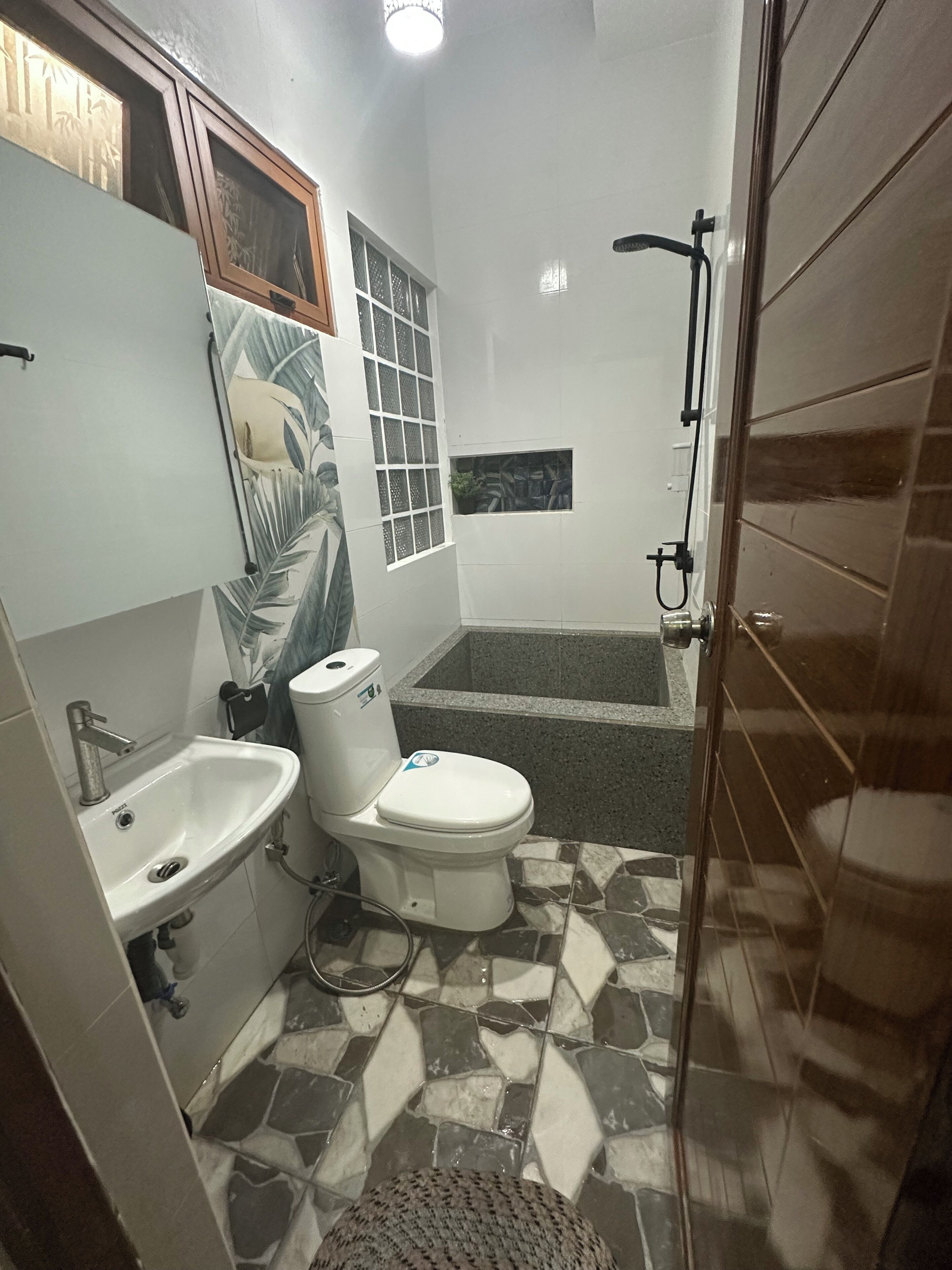 A bathroom with a sink, toilet, and shower.