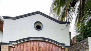 Un gran portón de madera con un muro de piedra y un letrero que dice 'The Waves' de Francisco Casier.