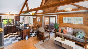 A rustic cabin interior with a kitchen, dining area, and living room.