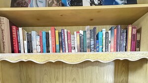 Une bibliothèque remplie de divers ouvrages et une platine vinyle.