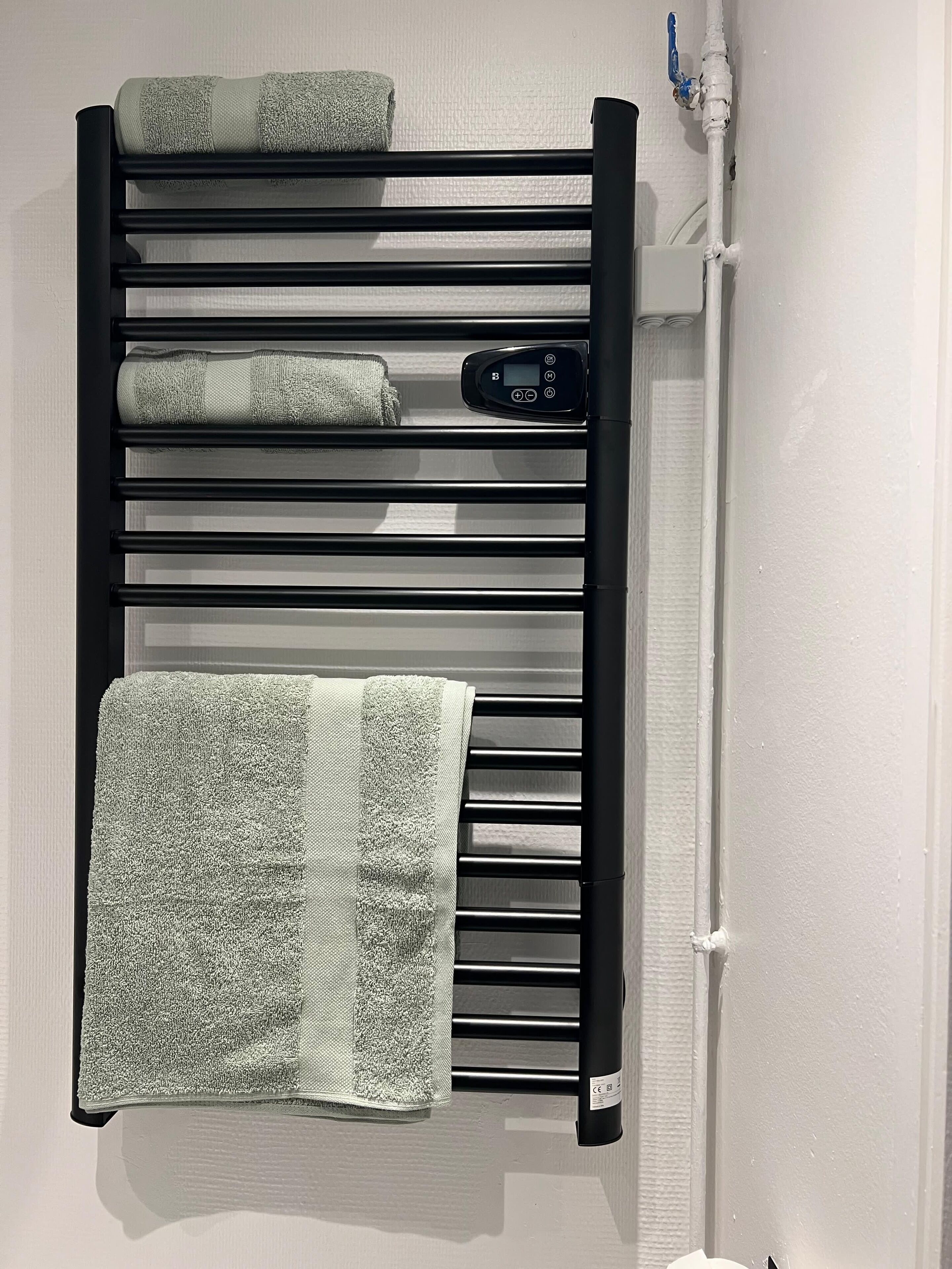 A towel rack with multiple towels and a control panel.