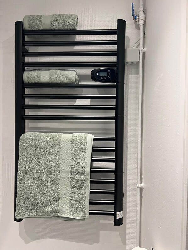 A towel rack with multiple towels and a control panel.