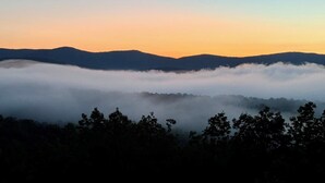 Un paisaje montañoso con una capa de niebla a los pies de las colinas.