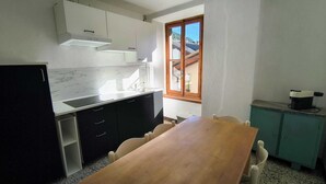 A compact kitchen with a wooden table, a sink, and cabinets. - BLACK DOLOMYTE Apartment (Schilpario)