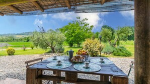 An outdoor dining area with a table set for two, a coffee pot, and a fruit bowl. - Appartamento rustico con piscina nell'antico "Podere la Querciola, Guardistallo" (Guardistallo)