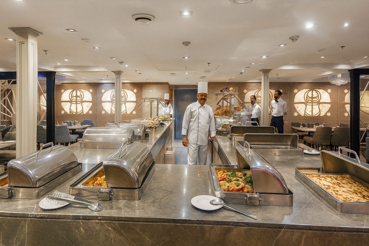 Ein reichhaltiges Buffet mit mehreren Speiseauslagen und Servicepersonal.