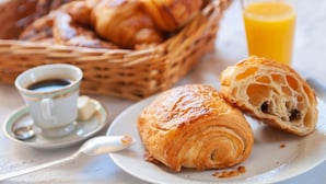 A breakfast setting with croissants, a glass of orange juice, and a cup of coffee. - Chez Christophe Pauillac  (Pauillac)