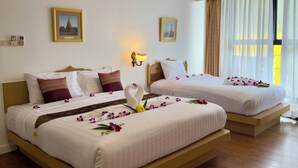 A hotel room with two beds, wooden flooring, and a large window with sheer curtains. - Neptuna Kata Beach Phuket (Karon)