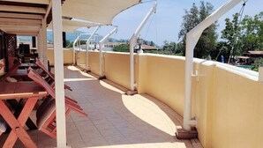 A covered outdoor area with a long bench and a tiled floor. - Neptuna Kata Beach Phuket (Karon)