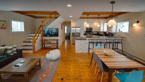 A spacious living area with a wooden staircase, a kitchen with modern appliances, and a dining area with a large table and chairs. - Three Peaks Hideaway, a Tranquil 4-bedroom house with Mountain Views in Peru (Peru)
