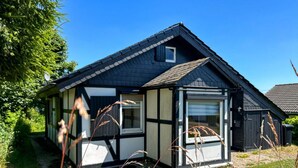 Ein traditionelles Haus mit Giebeldach, kleinem Fenster und einer Tür.