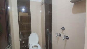 A bathroom with a toilet, a shower, and a sink. - The haveli lounge and restaurant (Udaipur)