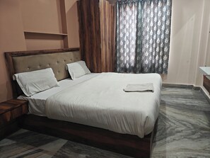 Una cama bien hecha con cabecera de madera y suelo con diseño de mármol.