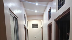 A hallway with a marble floor, wooden doors, and a ceiling with recessed lighting. - The haveli lounge and restaurant (Udaipur)