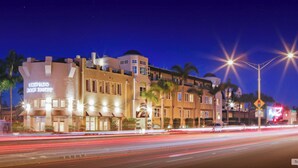 A hotel with a prominent sign reading "CORONADO BEACH RESORT" and a modern architectural design with multiple stories and balconies. - Celebrate winter holidays at the lovely, warm, welcoming Coronado Beach Resort! (Coronado)