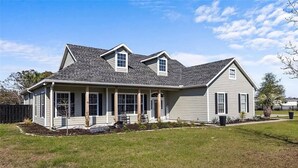 A single-story house with a covered porch, a small front yard, and a fenced backyard. - Ranch House w/ Pools, Pickleball, Sand Volleyball 10 mins to Springs (High Springs)