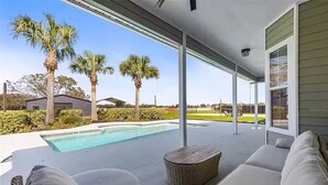 A covered outdoor area with a pool, seating, and palm trees. - Ranch House w/ Pools, Pickleball, Sand Volleyball 10 mins to Springs (High Springs)