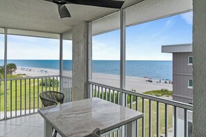 Ein Balkon mit Blick auf Strand und Meer.